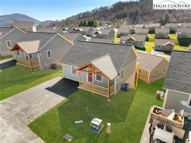 an aerial view of a house with swimming pool and a yard