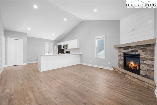 a view of empty room with wooden floor and fireplace