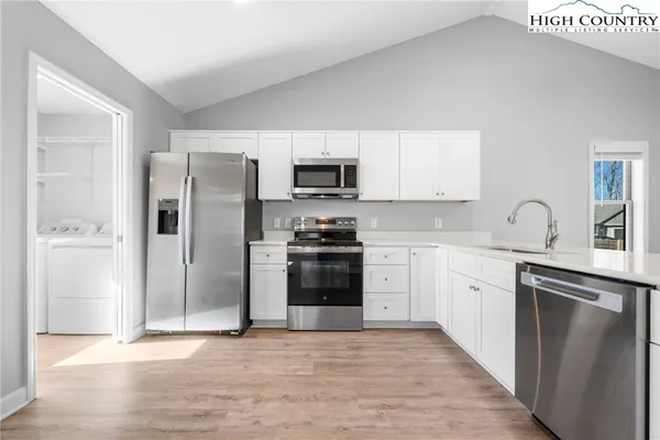 a kitchen with granite countertop a refrigerator stove and sink
