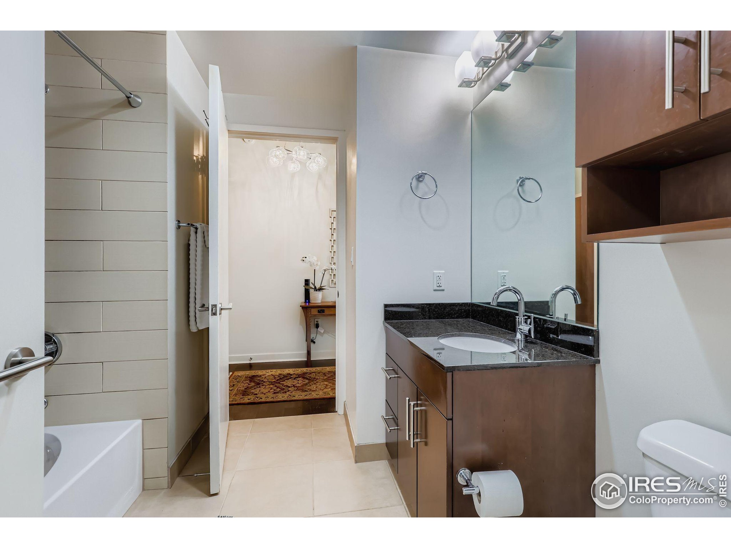 891 14th Street, Unit 1111 Denver, CO 80202 - Photo 12 of 38 a bathroom with a granite countertop sink a toilet and shower