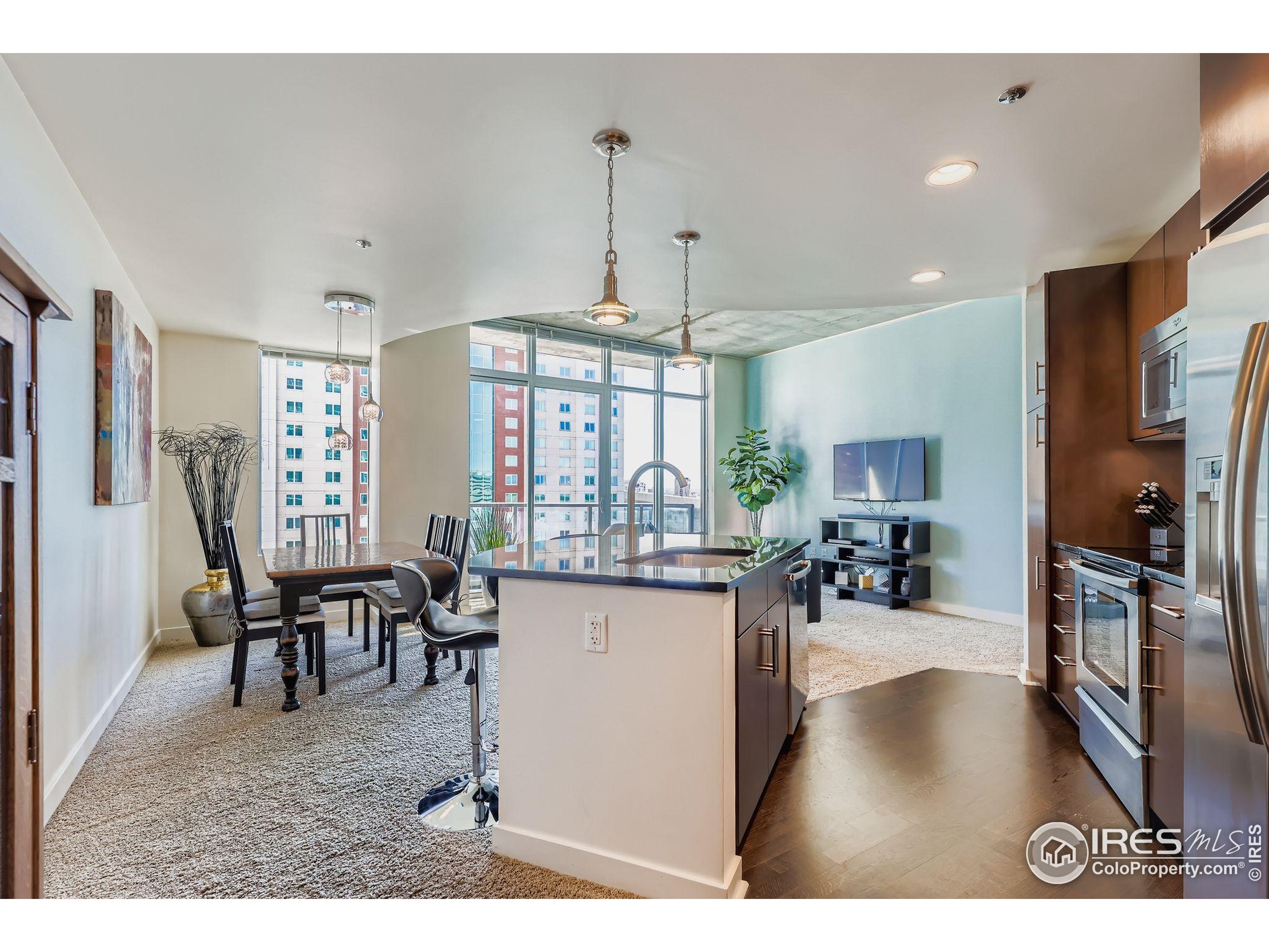 891 14th Street, Unit 1111 Denver, CO 80202 - Photo 3 of 38 a view of a dining room and livingroom with furniture wooden floor a chandelier