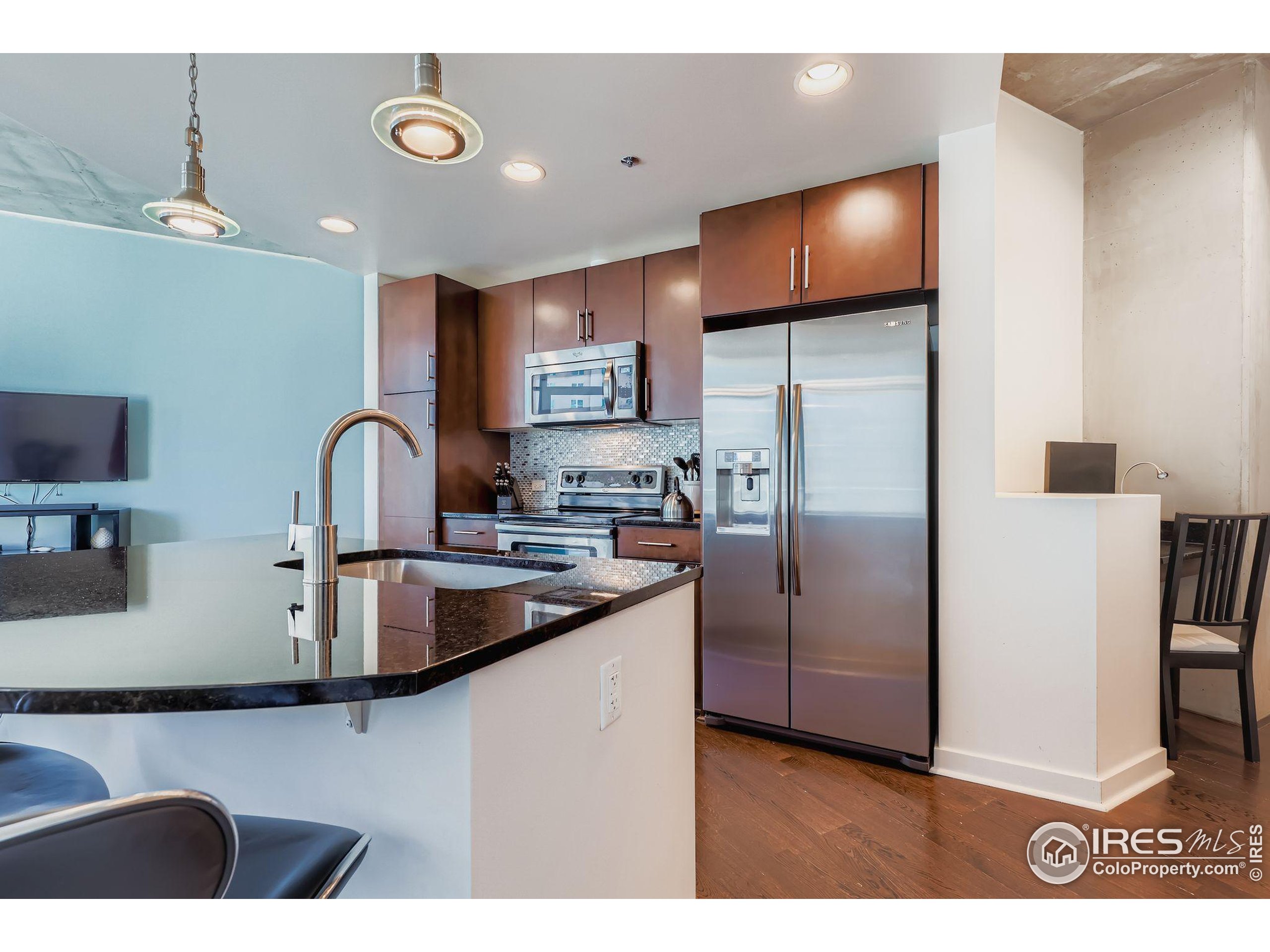 891 14th Street, Unit 1111 Denver, CO 80202 - Photo 4 of 38 a kitchen with stainless steel appliances granite countertop a sink a stove and refrigerator