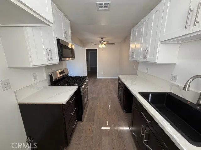 a kitchen with stainless steel appliances a sink stove and microwave
