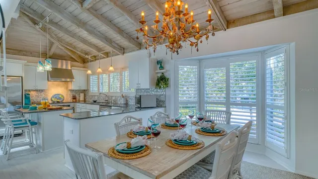 a view of a dining room and livingroom with furniture wooden floor and a chandelier