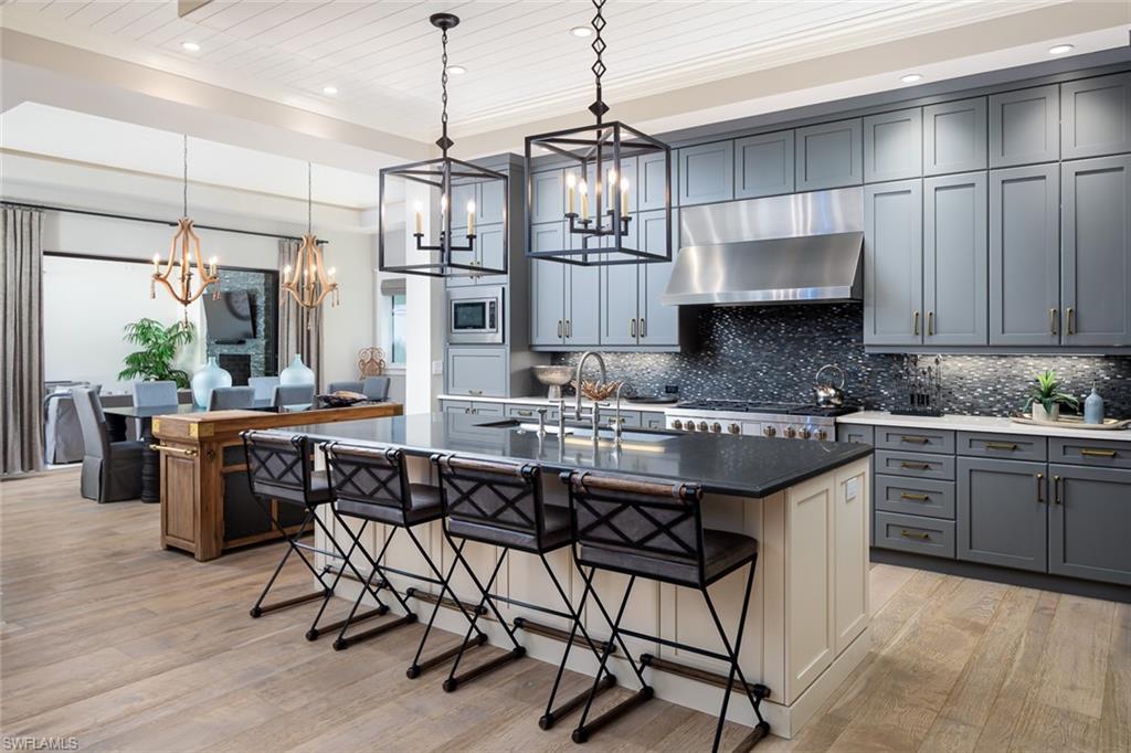 3170 Crayton Road Naples, FL 34103 - Photo 11 of 50 a kitchen with stainless steel appliances granite countertop a sink a stove a refrigerator and cabinets