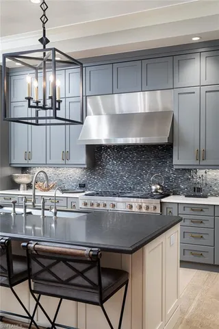 a kitchen with kitchen island granite countertop a sink cabinets and stainless steel appliances