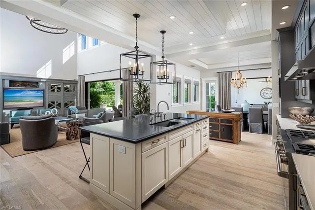 a kitchen with stainless steel appliances granite countertop a sink a stove and a wooden floors