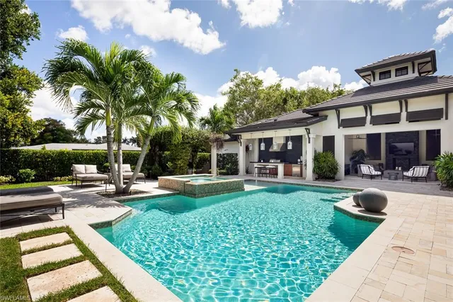 a view of a house with backyard sitting area and swimming pool