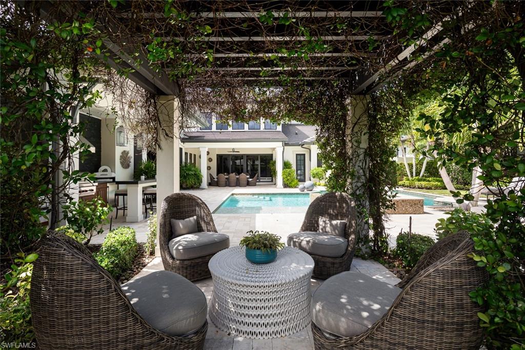 3170 Crayton Road Naples, FL 34103 - Photo 26 of 50 a view of a patio with couches chairs and a potted plant