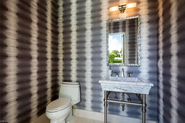 a bathroom with a granite countertop toilet a sink and a mirror