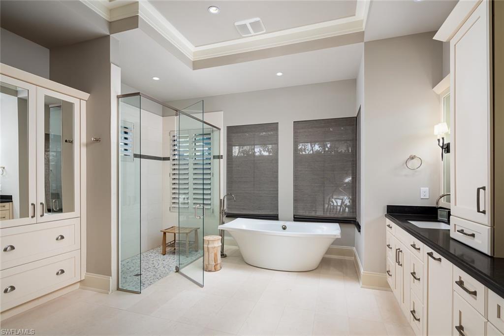 3170 Crayton Road Naples, FL 34103 - Photo 29 of 50 a spacious bathroom with a double vanity sink a mirror and a glass door shower