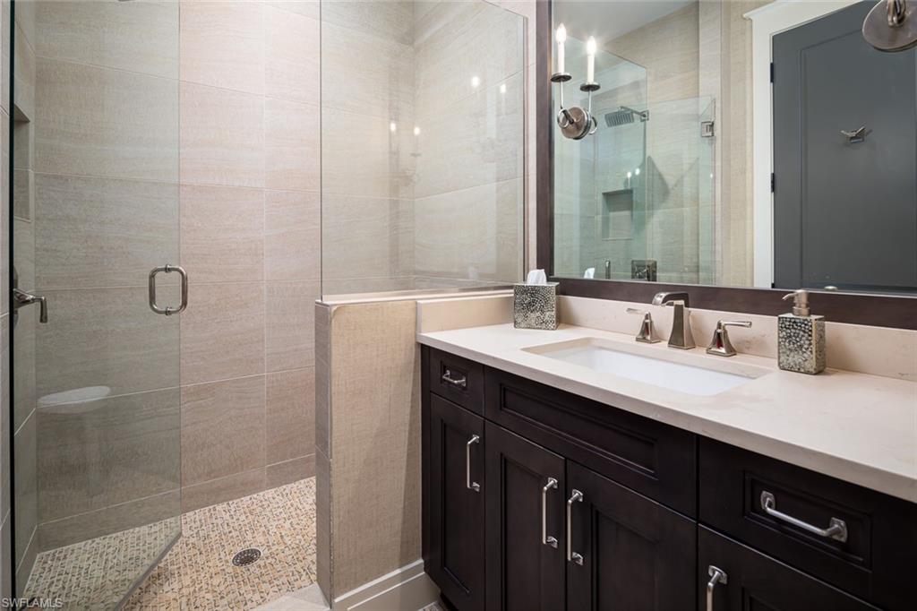 3170 Crayton Road Naples, FL 34103 - Photo 34 of 50 a bathroom with a double vanity sink mirror and shower