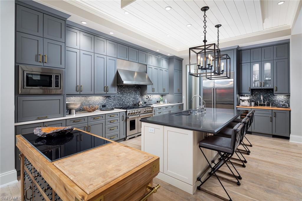 3170 Crayton Road Naples, FL 34103 - Photo 9 of 50 a kitchen with stainless steel appliances a stove a sink a stove a refrigerator cabinets and a dining table