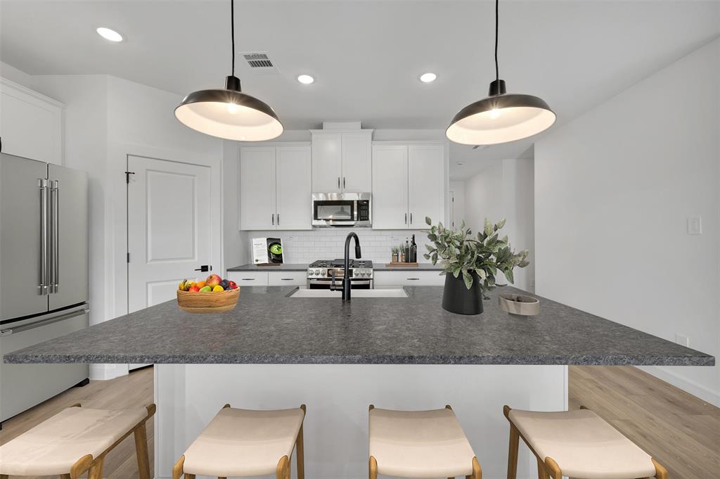 175 Summer Rain Way Newark, TX 76071 - Photo 5 of 39 a view of a kitchen with kitchen island a counter space and a sink