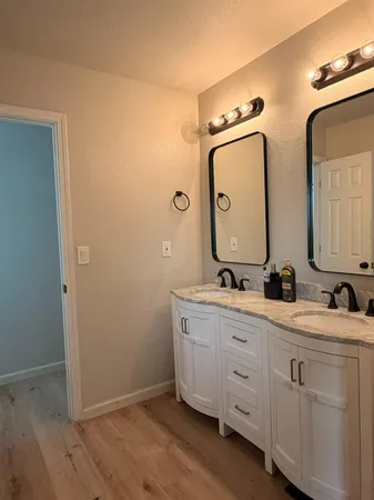 a bathroom with double vanity sink two mirror and a shower