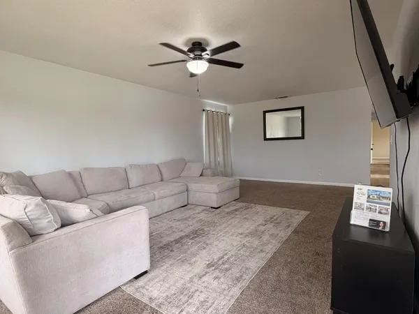 a living room with furniture and a ceiling fan
