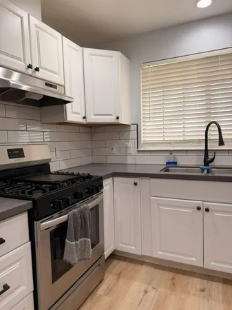 a kitchen with granite countertop white cabinets and appliances