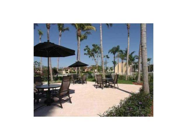 941 Lyons Road, Unit 5105 Coconut Creek, FL 33063 - Photo 18 of 22 a view of a patio with chairs under an umbrella