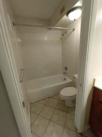 a bathroom with a granite countertop bathtub shower and toilet