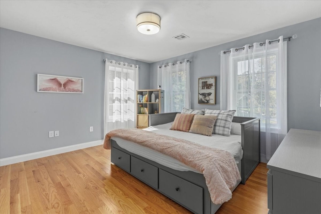 4 Lost Brook Trail Walpole, MA 02081 - Photo 25 of 42 a bedroom with a large bed and a chandelier