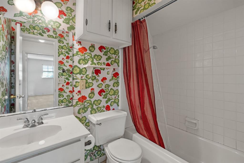 337 Town N Drive Terrell, TX 75160 - Photo 13 of 30 a white toilet sitting next to a bathroom sink and a shower curtain