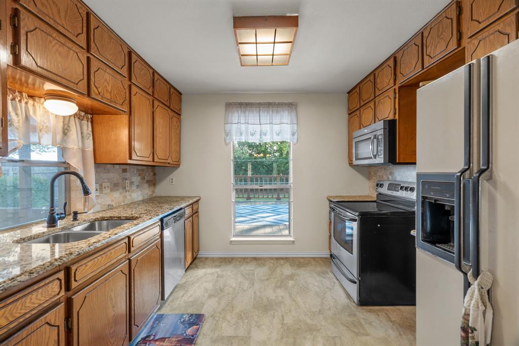 337 Town N Drive Terrell, TX 75160 - Photo 9 of 30 a kitchen with stainless steel appliances granite countertop a refrigerator and a sink