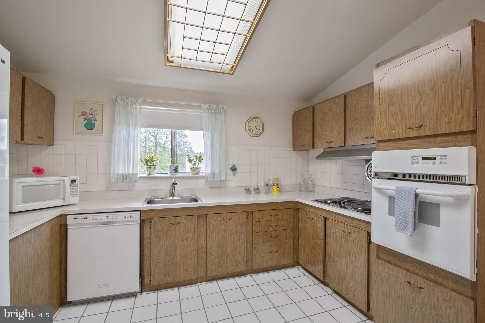 7504 Shelowood Road Baltimore, MD 21208 - Photo 11 of 29 a kitchen with a sink stove and cabinets