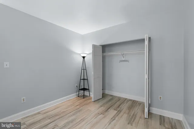 an empty room with wooden floor and a ceiling fan