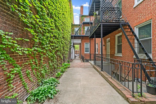 a view of a pathway of a house with backyard and wooden fence