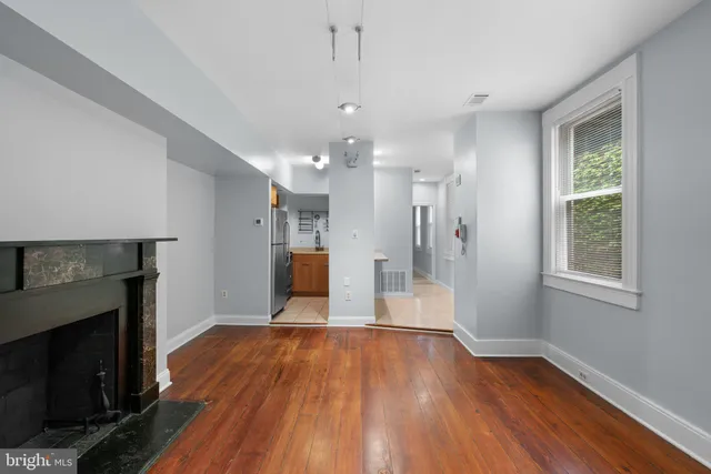 a view of a room with wooden floor and a fireplace