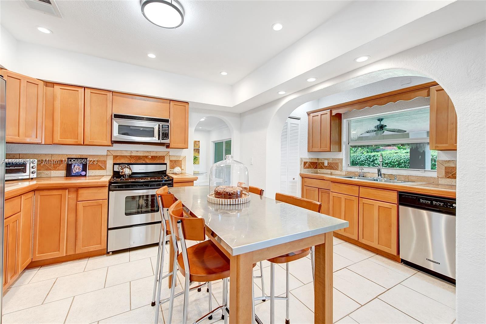 100 Southwest 26th Road Miami, FL 33129 - Photo 11 of 34 a kitchen with stainless steel appliances kitchen island granite countertop a stove top oven a sink and a granite counter tops