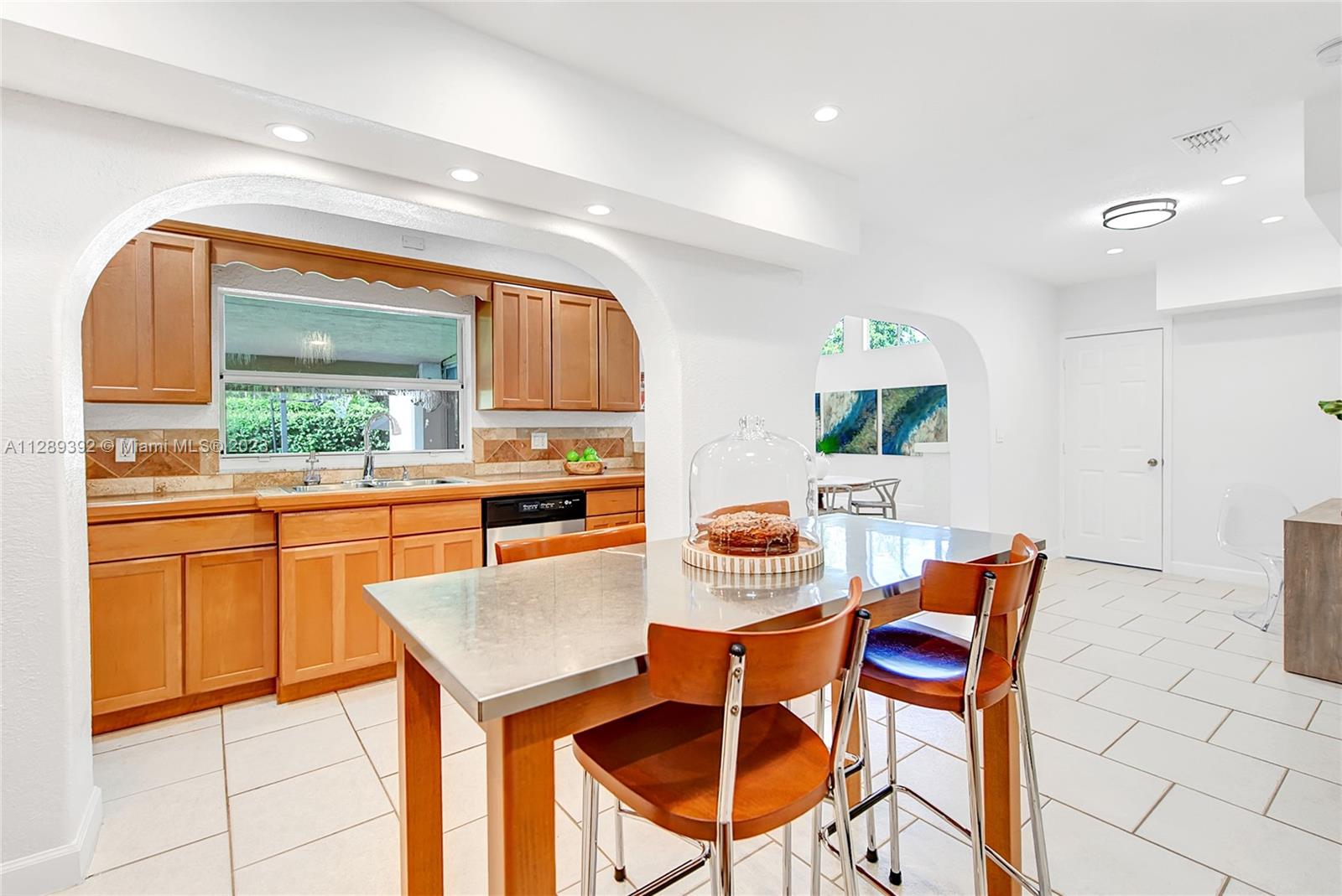 100 Southwest 26th Road Miami, FL 33129 - Photo 13 of 34 a kitchen with stainless steel appliances kitchen island granite countertop a table and chairs in it