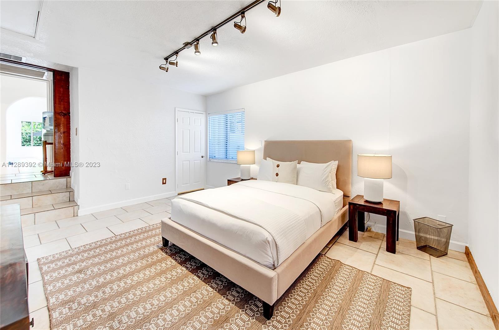 100 Southwest 26th Road Miami, FL 33129 - Photo 14 of 34 a bedroom with a bed and a night stand