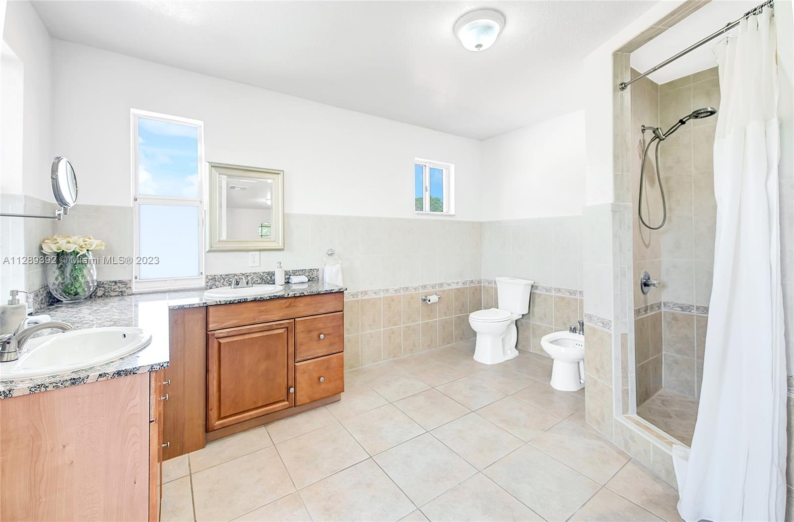 100 Southwest 26th Road Miami, FL 33129 - Photo 25 of 34 a bathroom with a granite countertop sink and a mirror