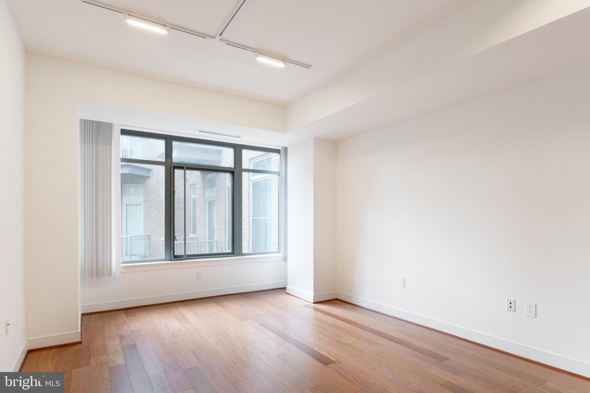 2425 L Street Northwest, Unit 431 Washington, DC 20037 - Photo 15 of 30 an empty room with wooden floor and windows