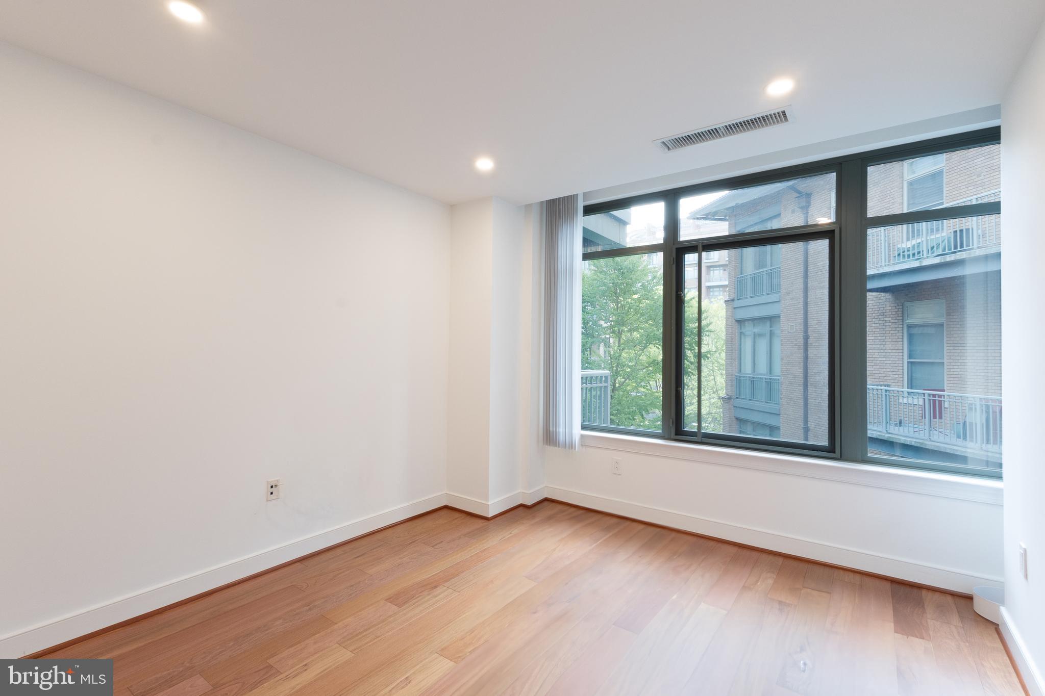 2425 L Street Northwest, Unit 431 Washington, DC 20037 - Photo 20 of 30 an empty room with wooden floor and windows