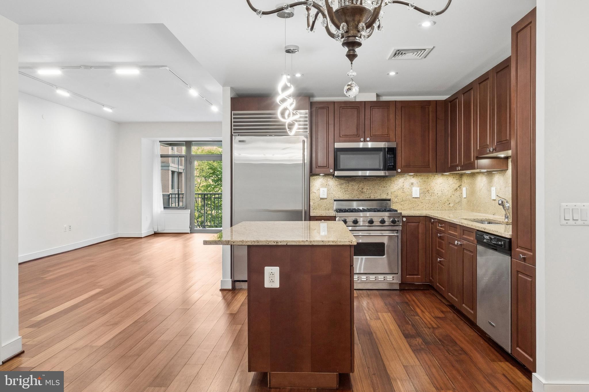 2425 L Street Northwest, Unit 431 Washington, DC 20037 - Photo 9 of 30 a kitchen with stainless steel appliances granite countertop a stove and a wooden floors