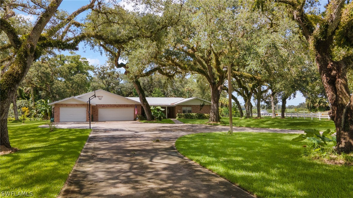 2340 Old N River Road LaBelle, FL 33935 - Photo 27 of 28 a white house with a big yard and large trees