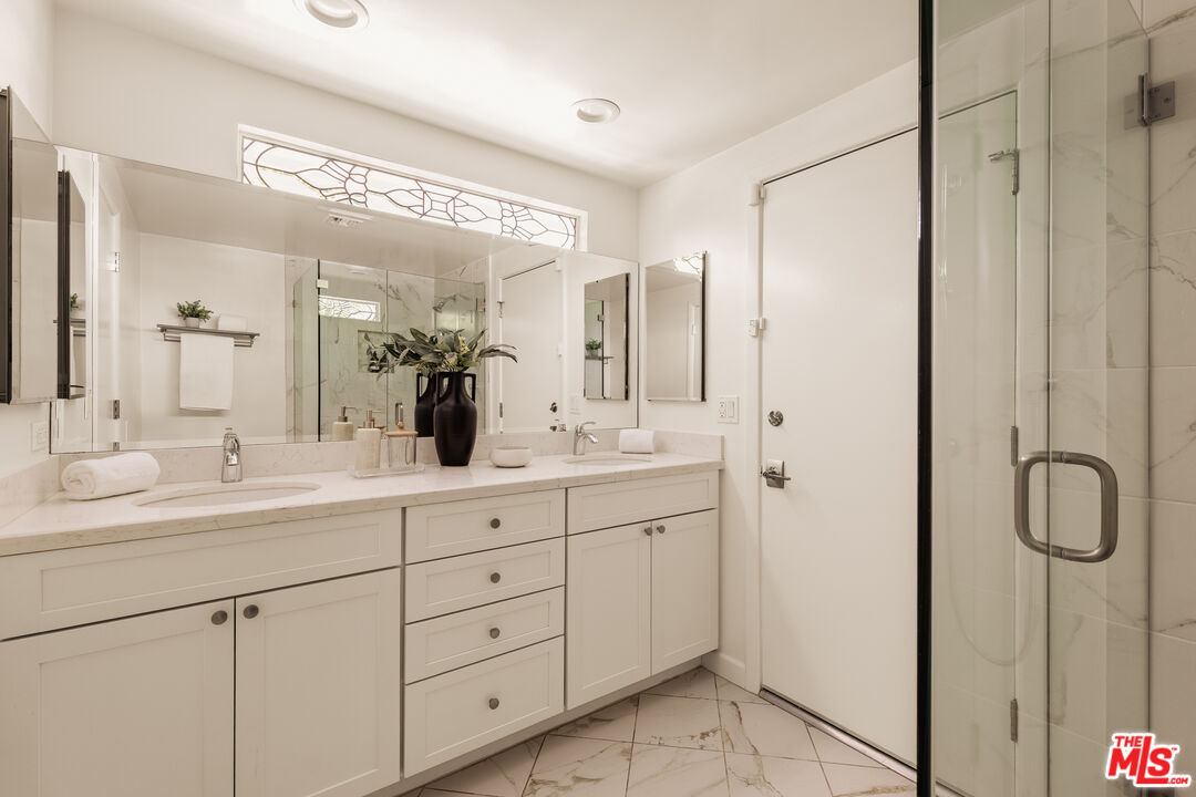 5124 South Corning Avenue Los Angeles, CA 90056 - Photo 16 of 30 a bathroom with a double vanity sink and a mirror