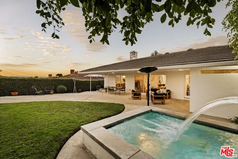 a view of yard with swimming pool and green space