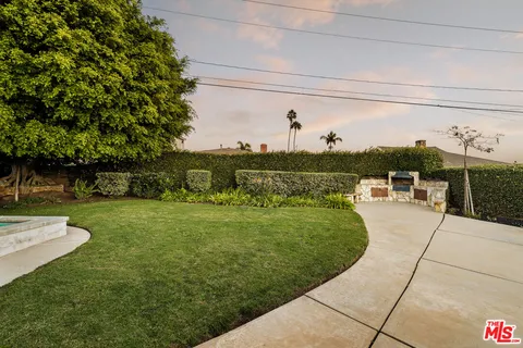 a view of a patio with table and chairs with plants and wooden fence