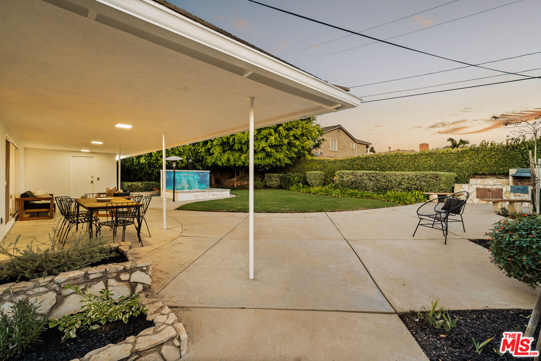 5124 South Corning Avenue Los Angeles, CA 90056 - Photo 8 of 30 a view of a patio with table and chairs with plants and wooden fence