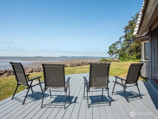 a view of a chairs and table on wooden deck with a dining space