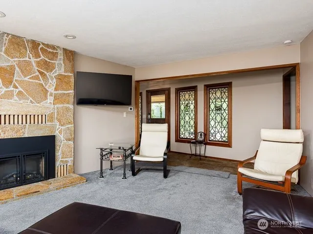 a living room with furniture a flat screen tv and a fireplace