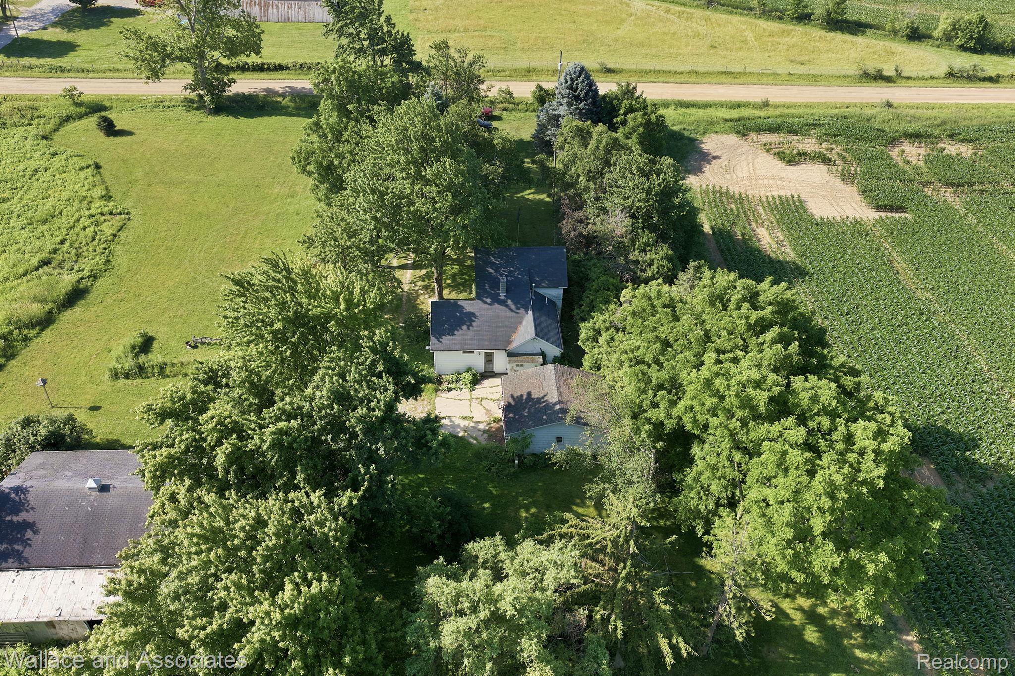 5949 Roach Road Croswell, MI 48422 - Photo 48 of 48 Expansive rural property featuring a main residence with a dark shingled roof, surrounded by mature trees