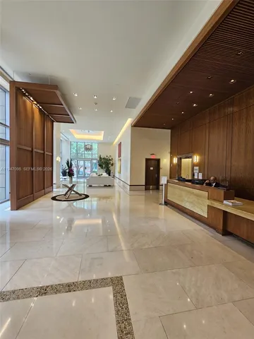 a lobby with furniture and a large mirror