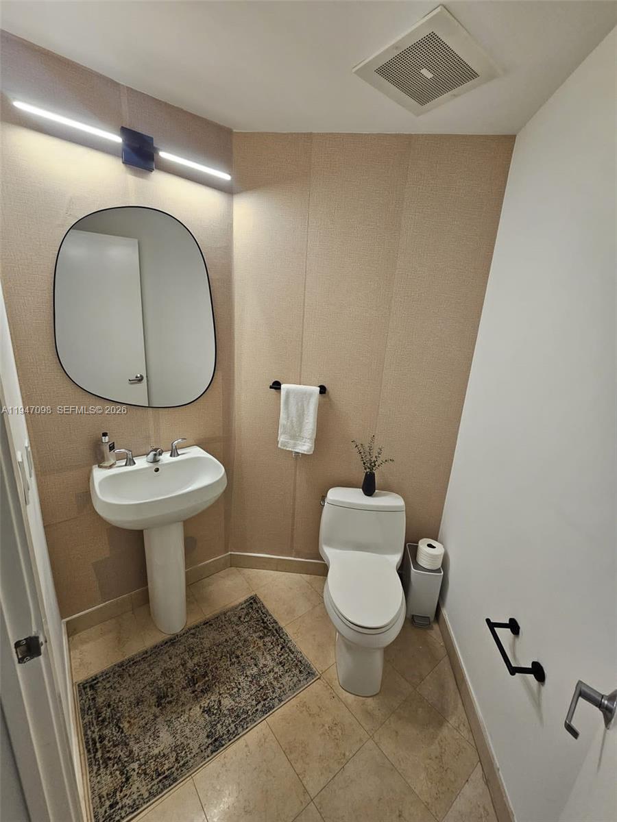 1060 Brickell Avenue, Unit 1917 Miami, FL 33131 - Photo 11 of 24 a bathroom with a toilet sink and mirror