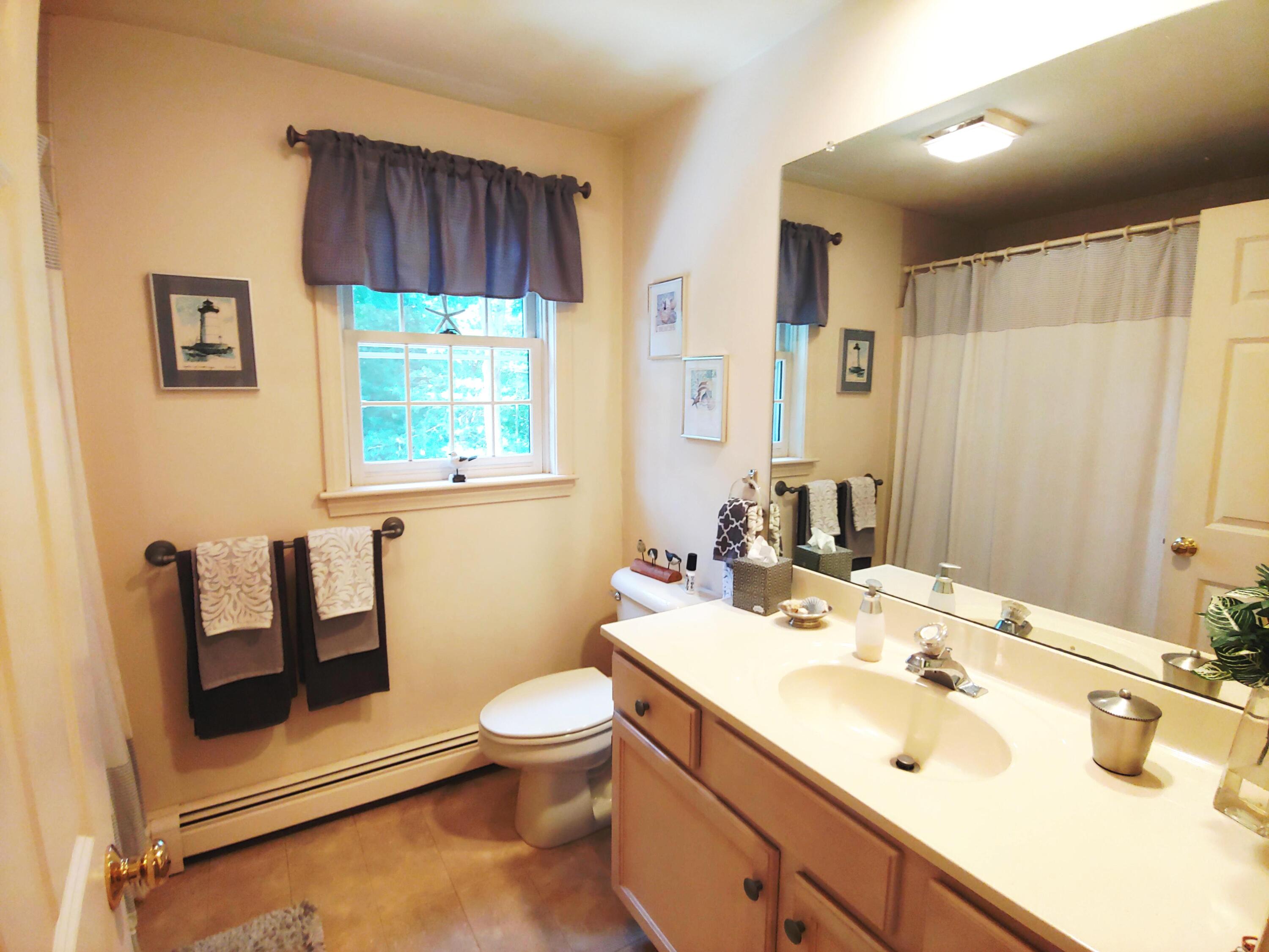 9 Rainbow Drive Centerville, MA 02632 - Photo 30 of 49 a bathroom with a sink a toilet and a mirror