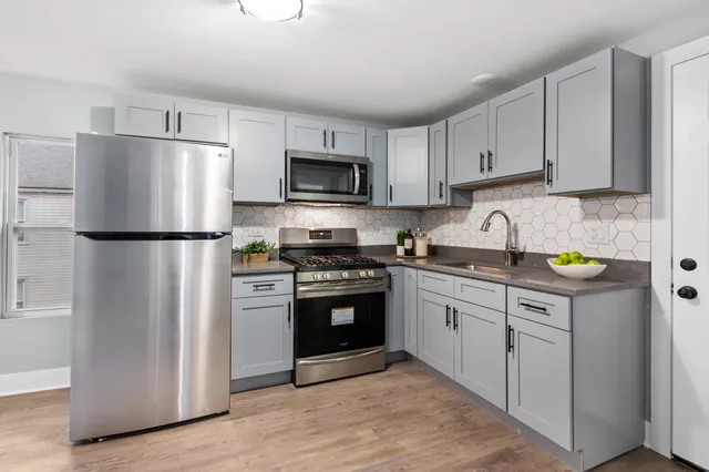 a kitchen with cabinets stainless steel appliances and a counter space