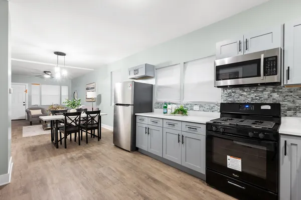 a kitchen with a stove a microwave and refrigerator